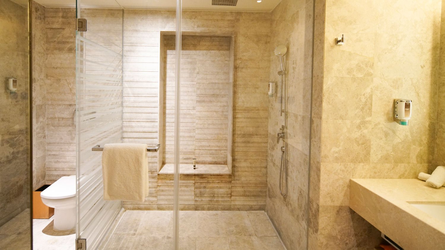 A glass shower door in a luxury bathroom