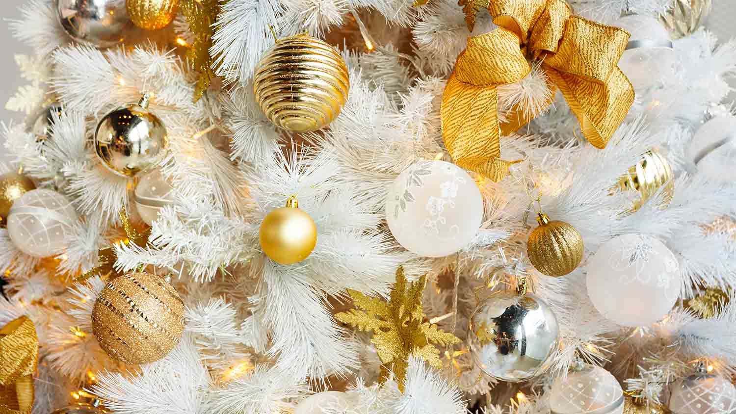 gold and silver ornaments on white christmas tree