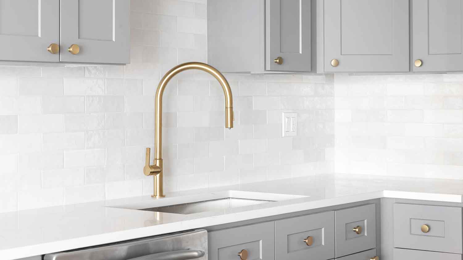 Brass gooseneck faucet installed in a modern kitchen