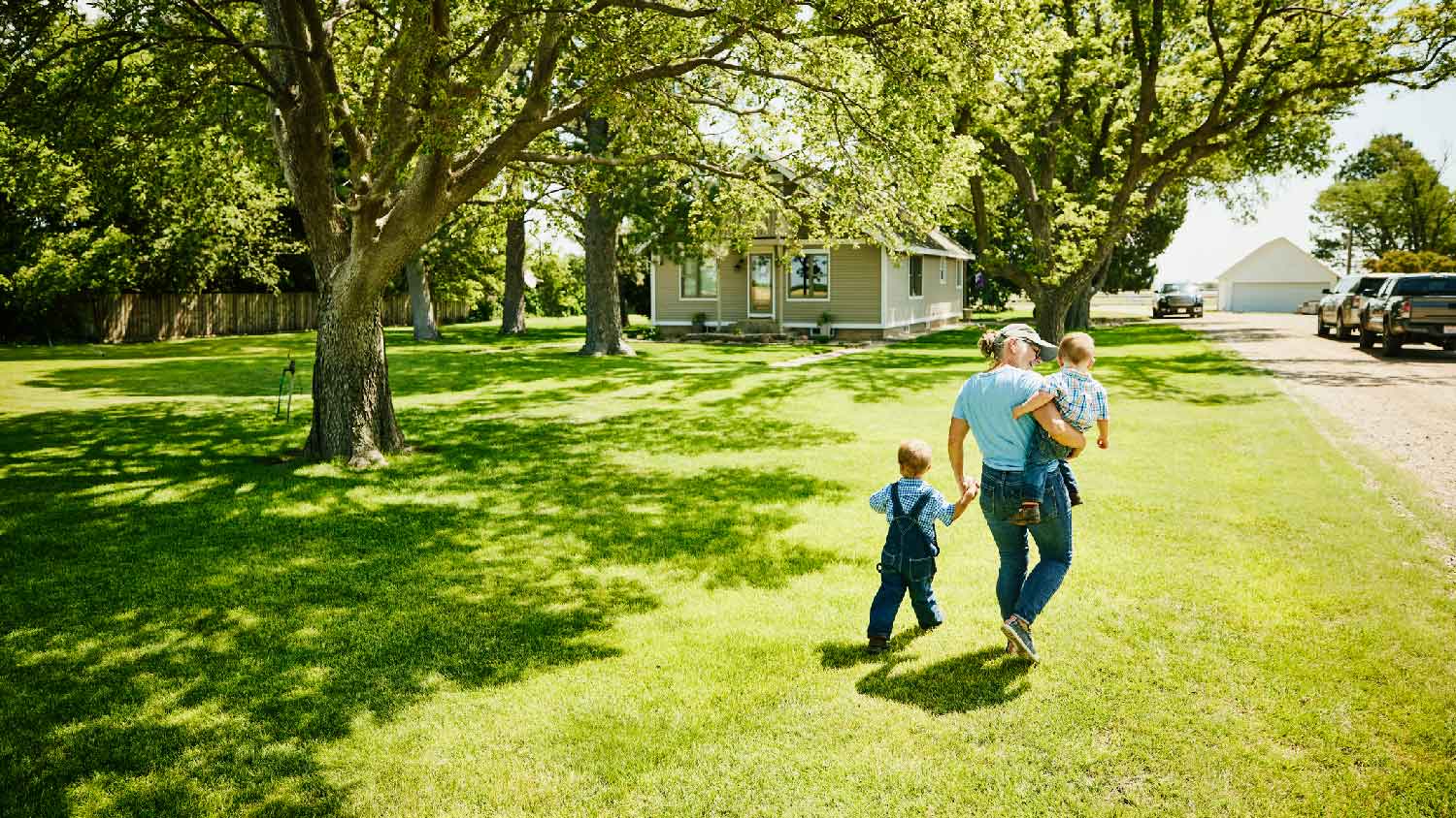 A grandmother walking in the yard with her grandsons