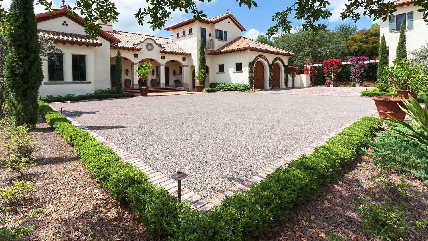 Villa with a gravel and brick paver driveway