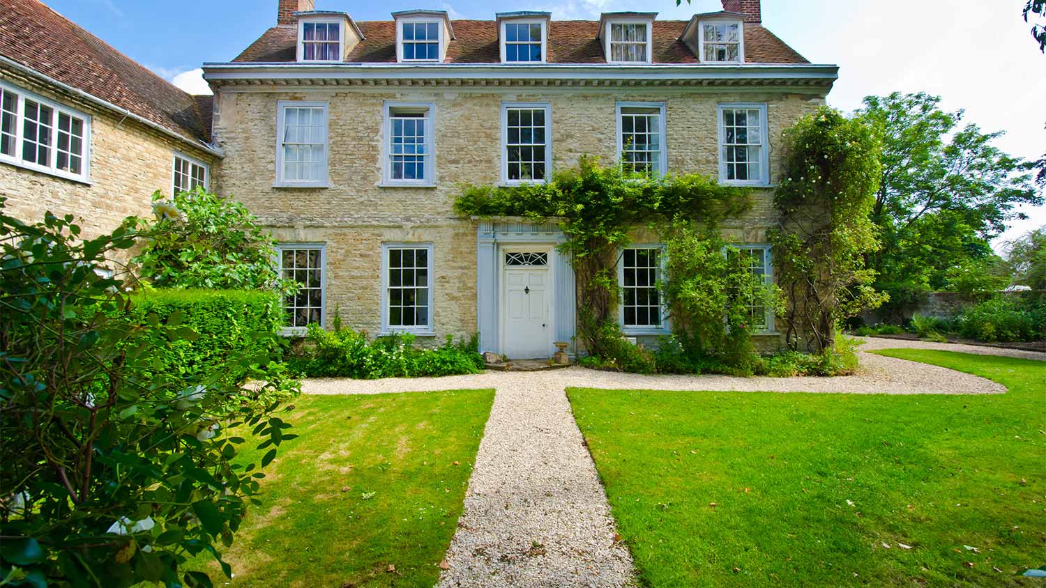 A gravel pathway leads to and around a historic home