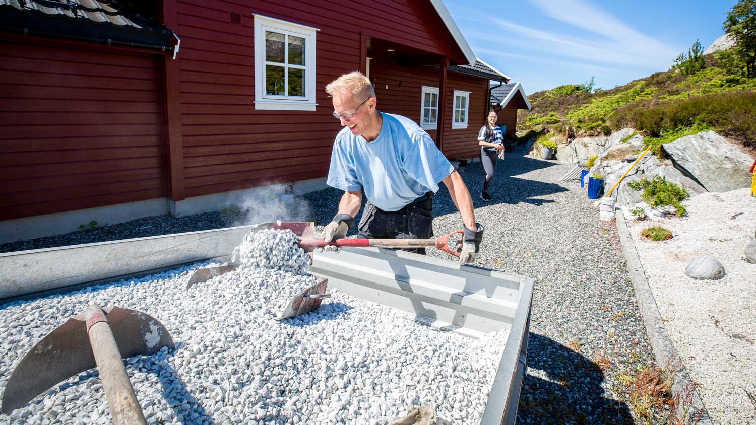 A man shoveling gravel from a truck