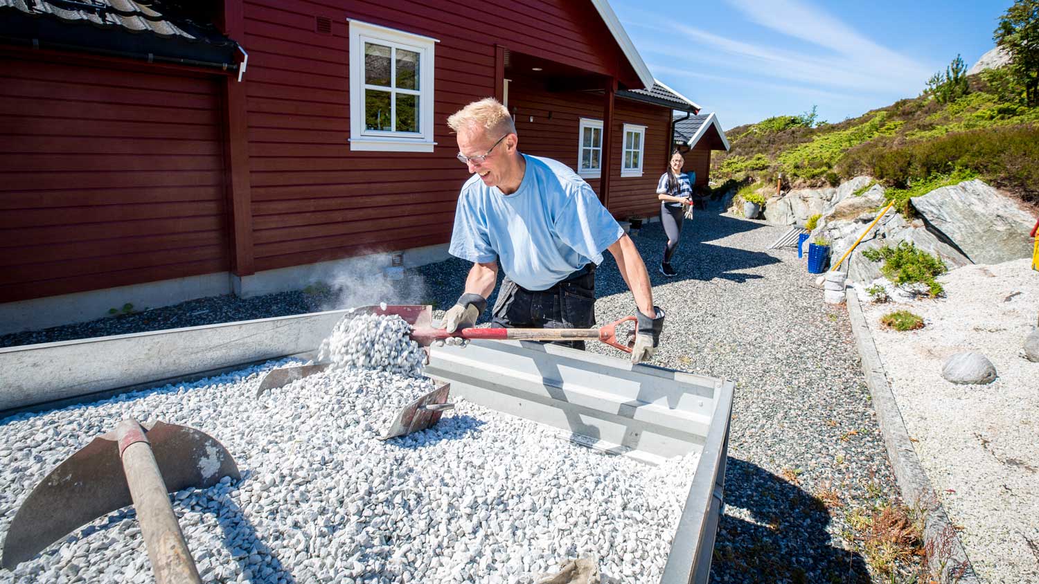 A man shoveling gravel from a truck 