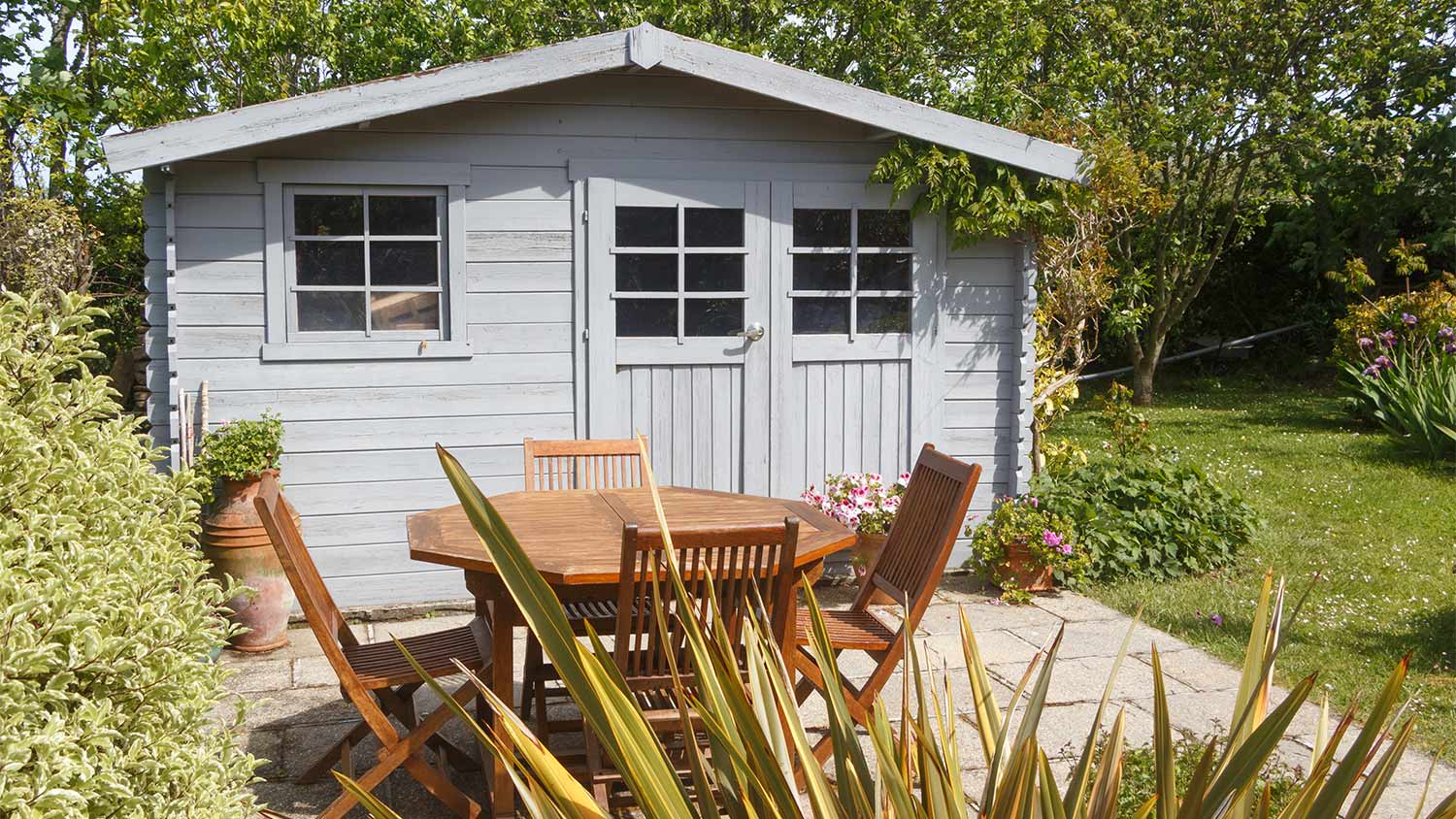 Backyard patio with shed and table.