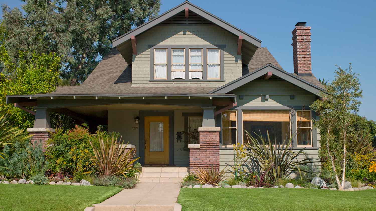 Green craftsman house with concrete front steps