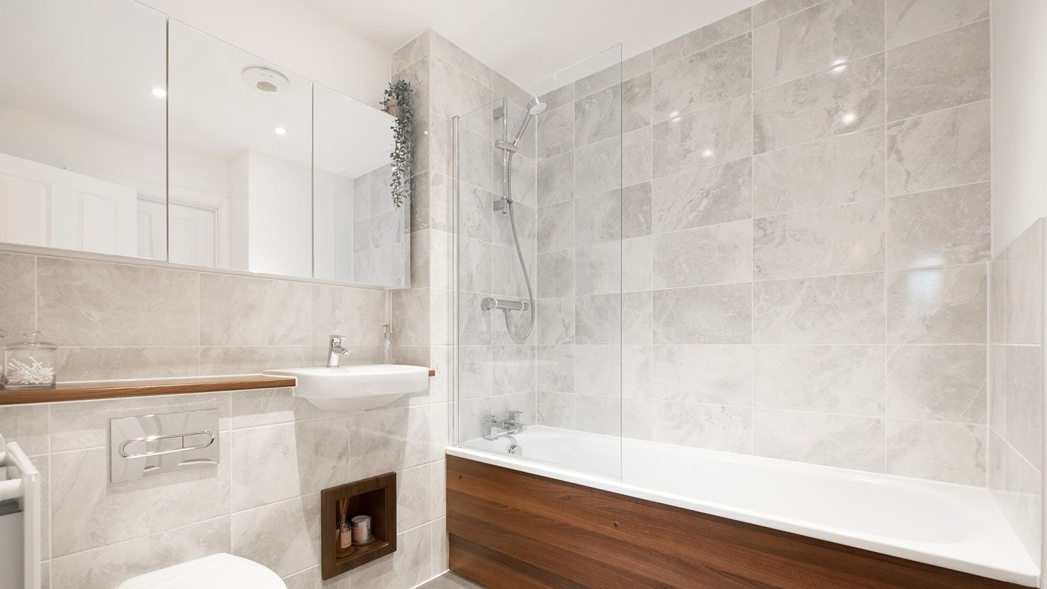 Grey tiled bathroom with large mirrored medicine cabinet