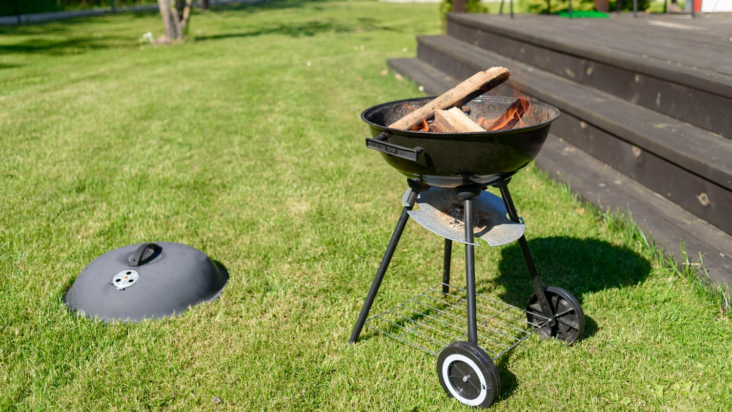 Grill with wood and fire in backyard