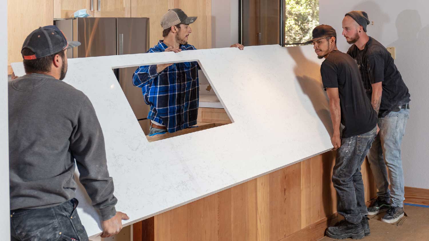 A group of people installing a quartz countertop