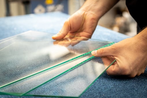 Person holding clear glass sheets