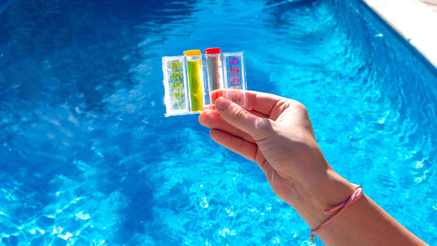 Hand holding a swimming pool test kit 
