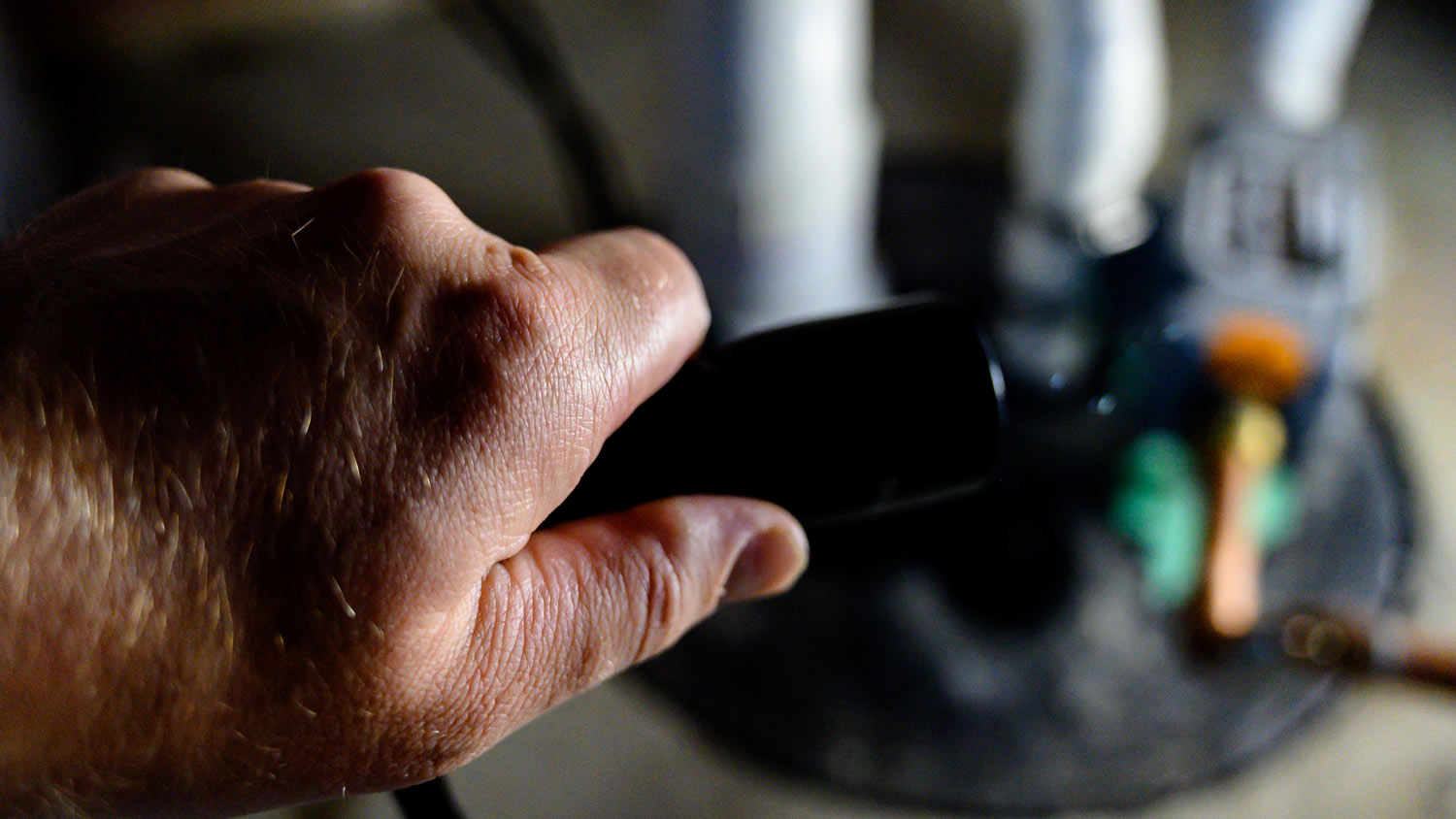 A hand of a plumber while repairing a sump pump