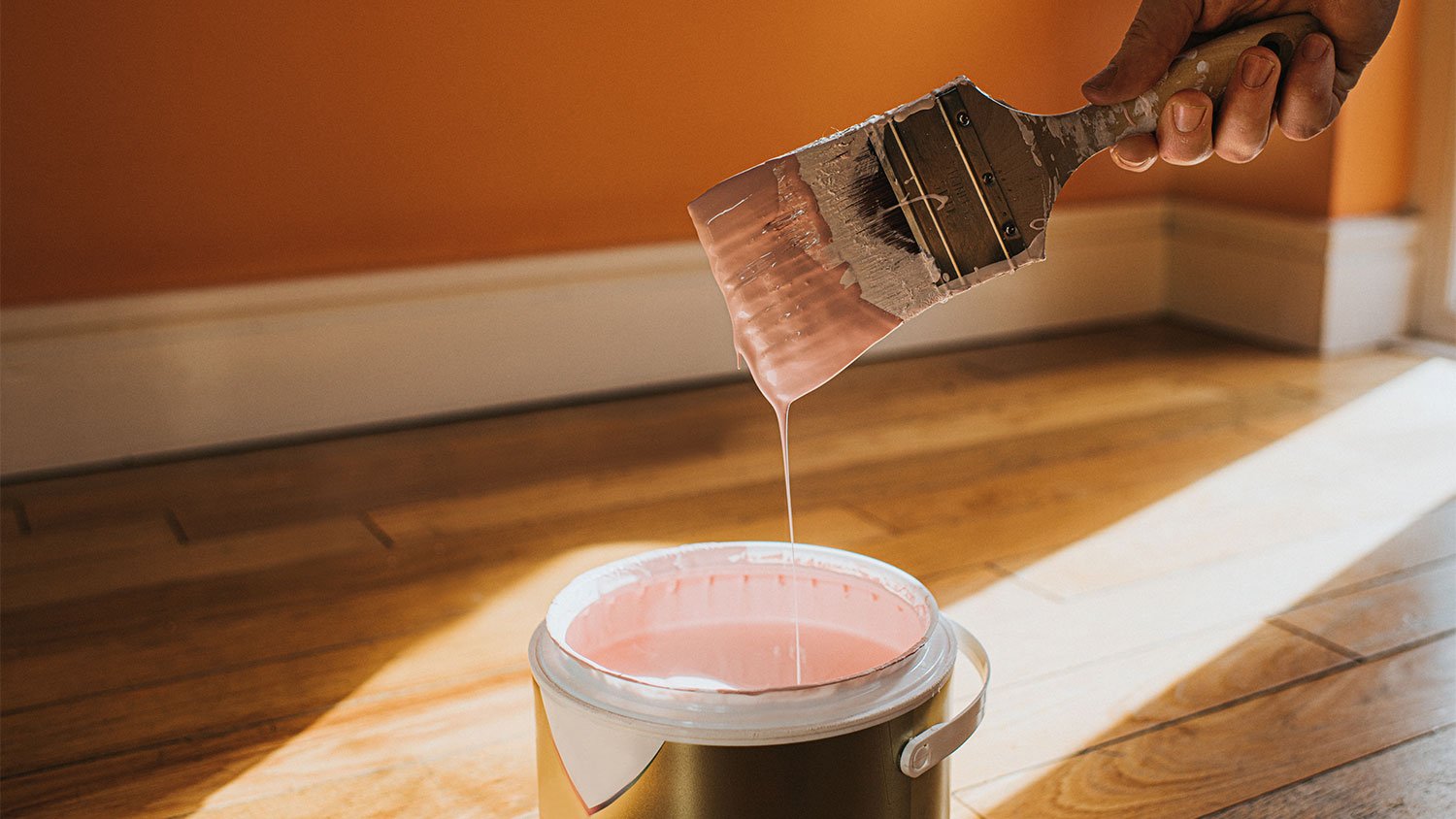A hand holds a paintbrush