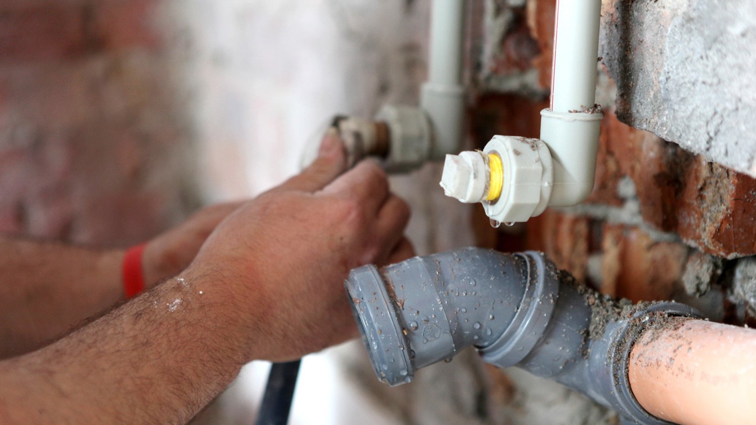 Plumber working on basement pipes