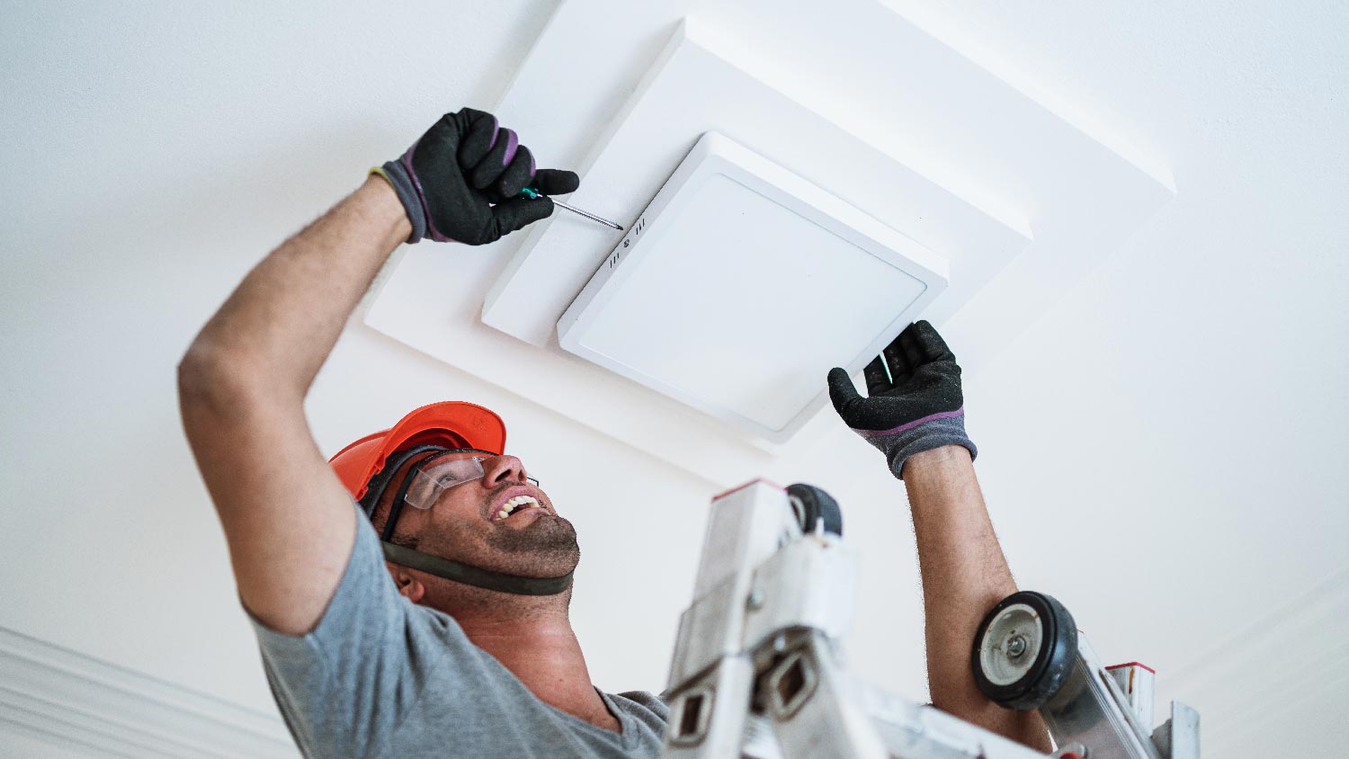 A handyman changing light bulb in the ceiling