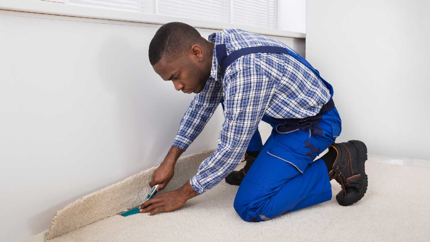 A handyman installing a carpet