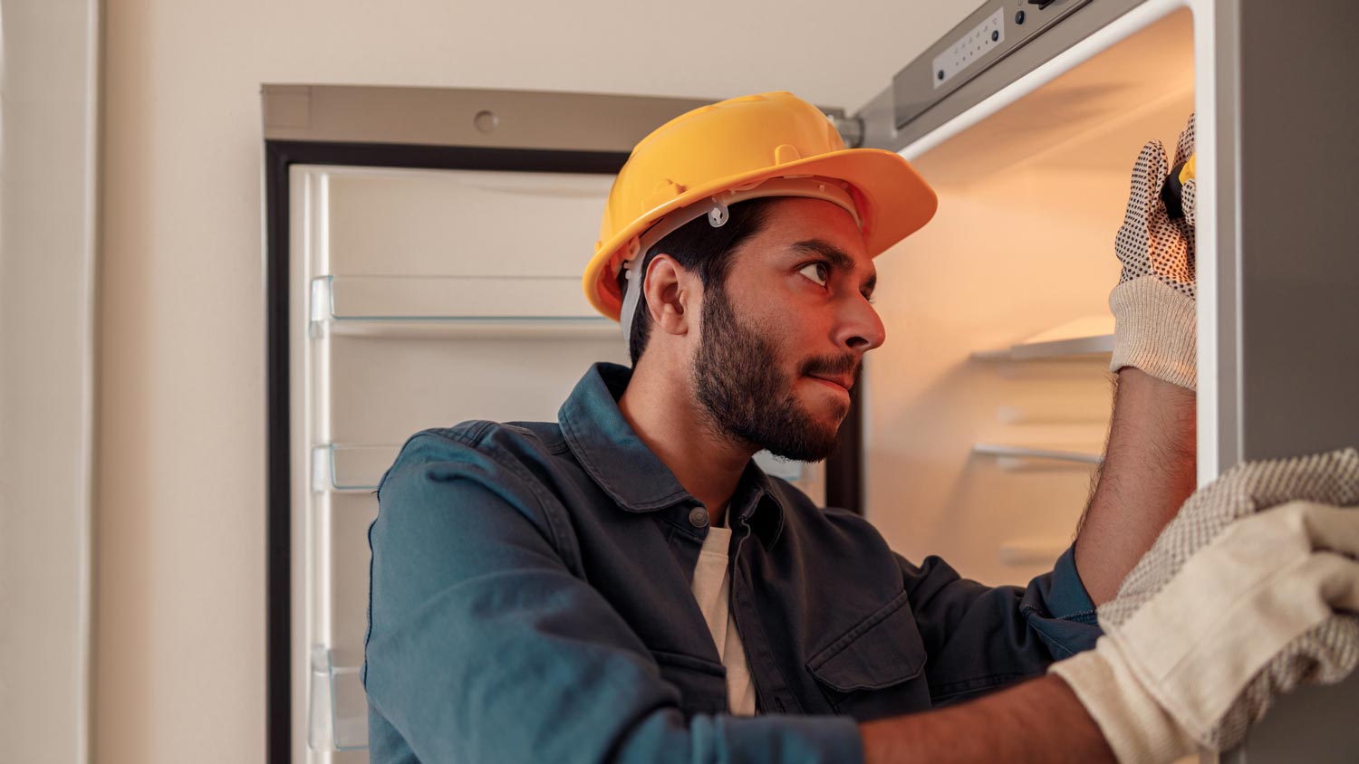 A handyman repairing a fridge