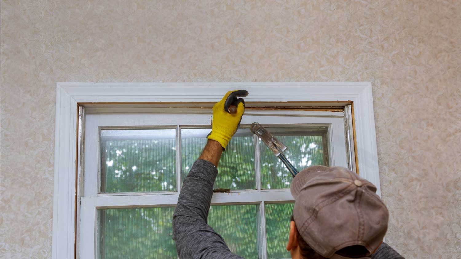 A handyman replacing a broken window