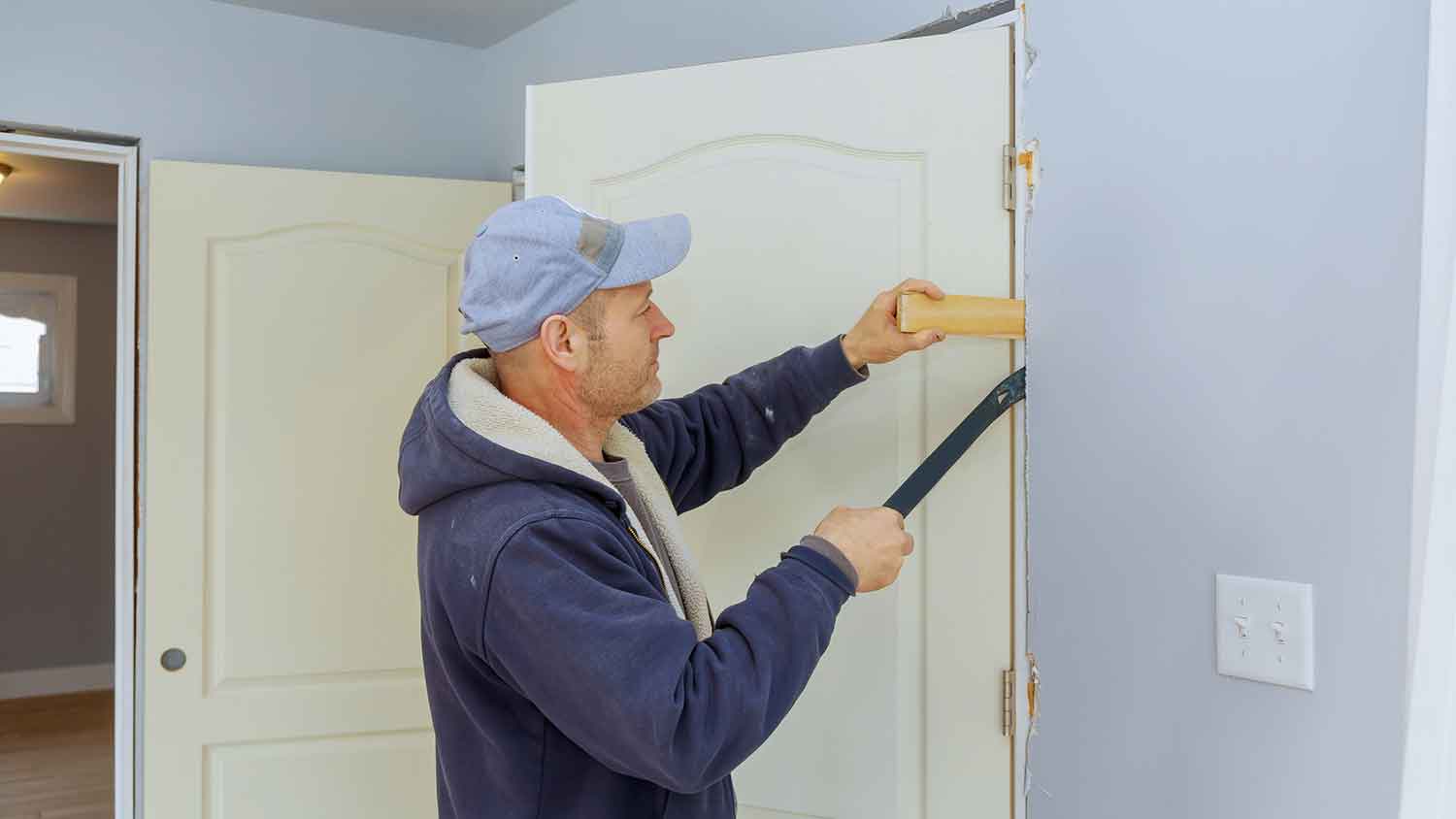 Handyperson installing new door frame in the house