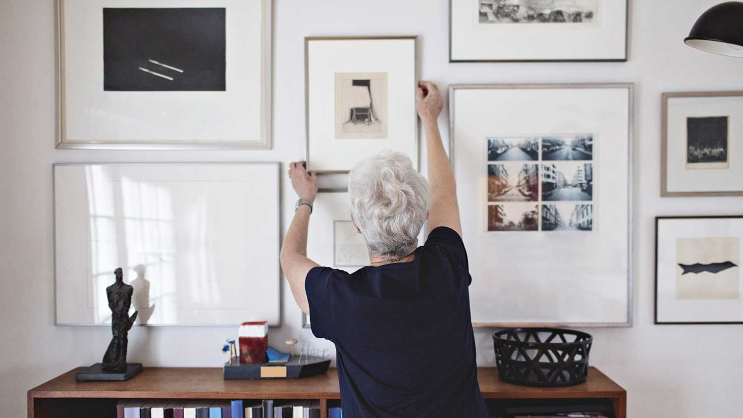 Woman hanging picture frame on the wall