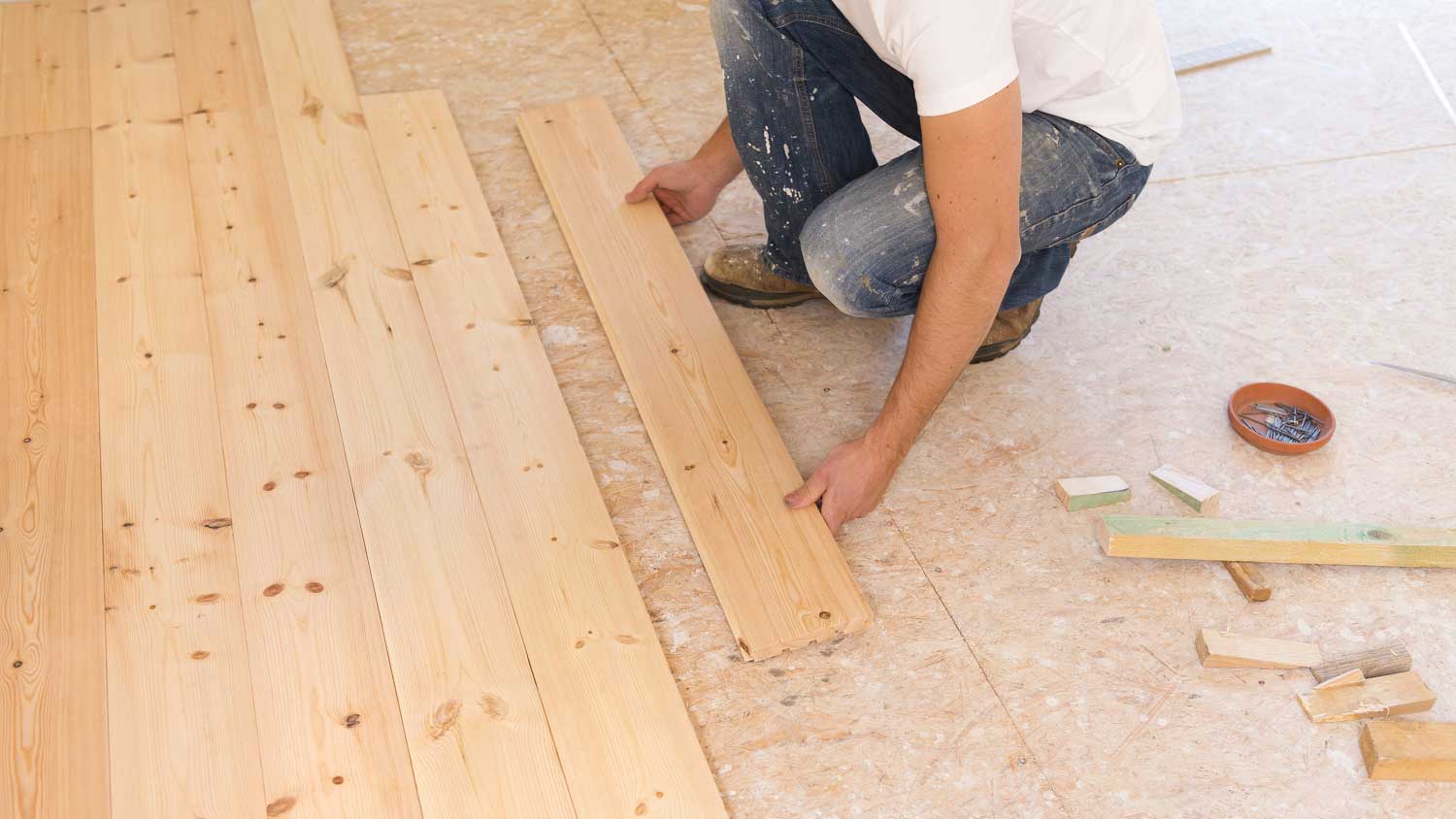 Contractor installing hardwood flooring in the room