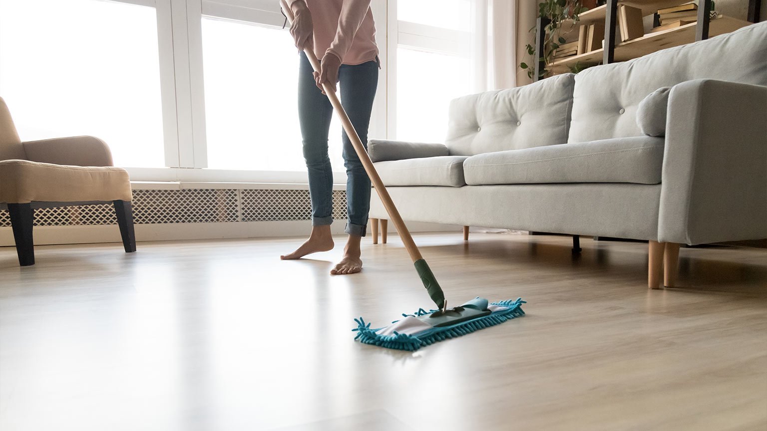 Barefoot woman cleaning floor with wet mop pad