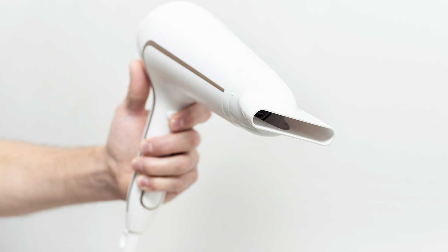 Hand holding a hair dryer on a white background