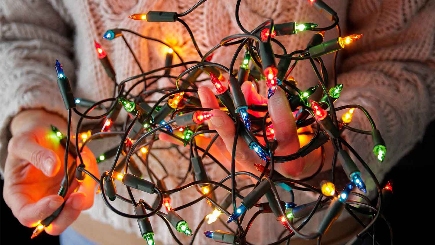 A closeup of someone holding Christmas tree lights