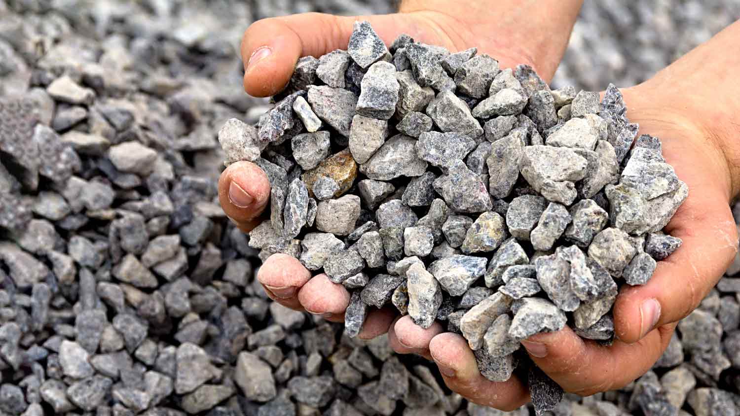 man holding  gravel in hand 