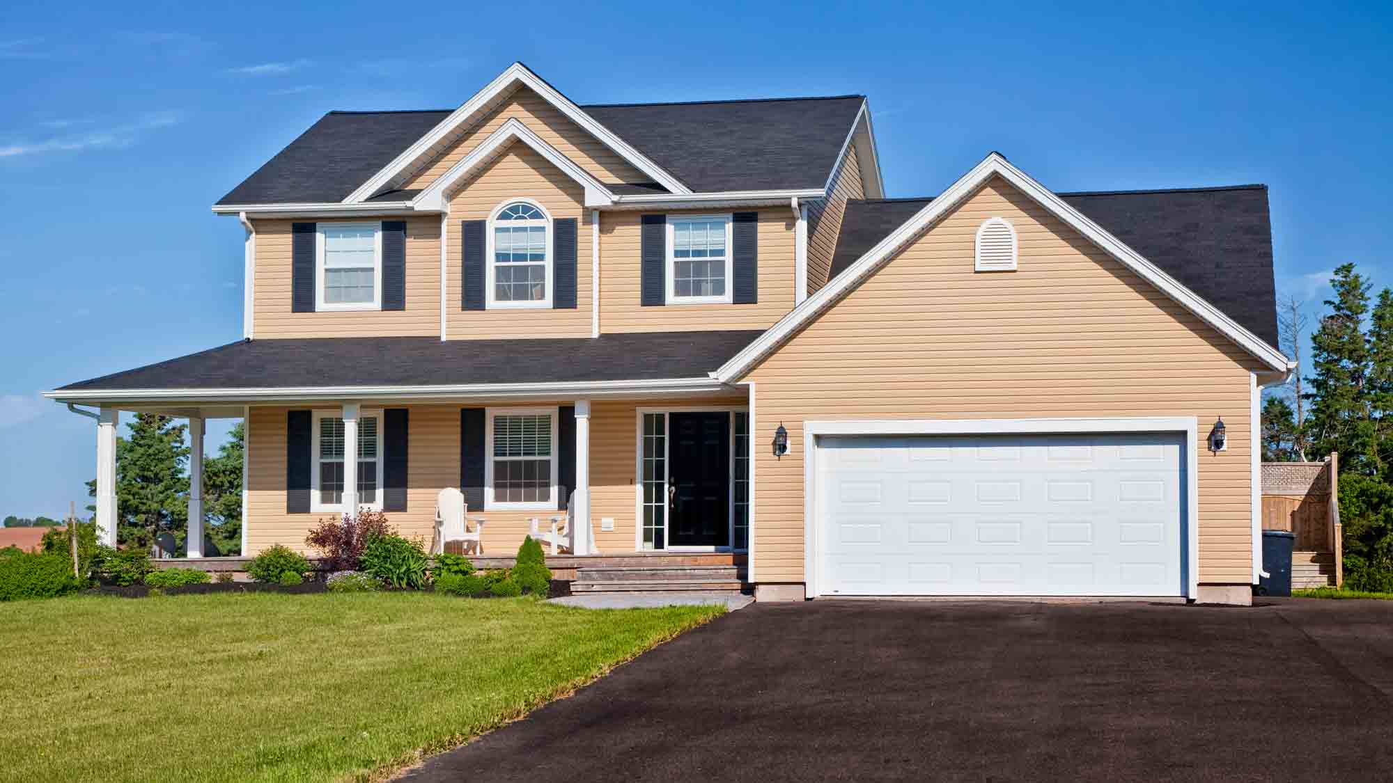 yellow home with asphalt driveway