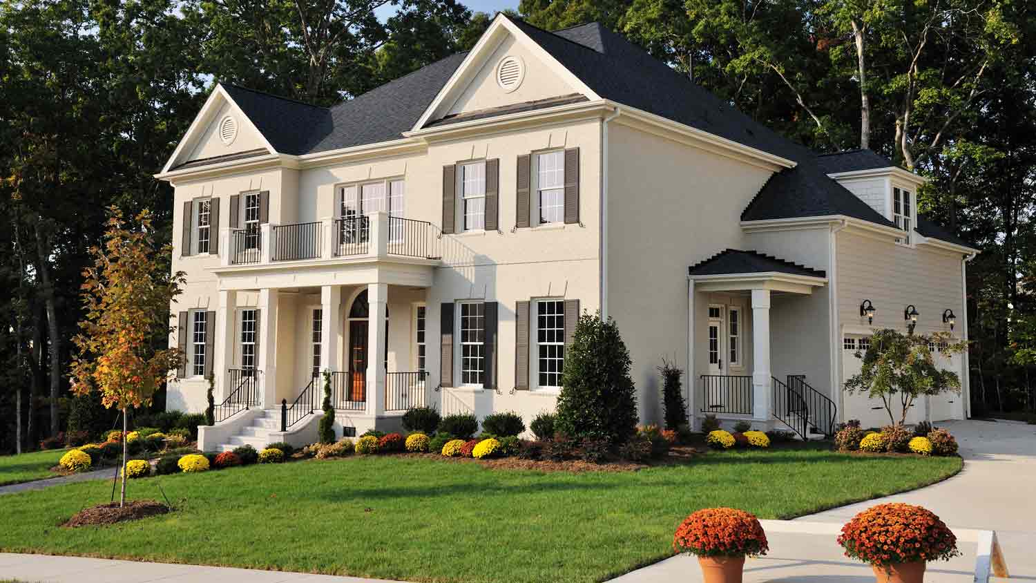 beige luxury home with black roof