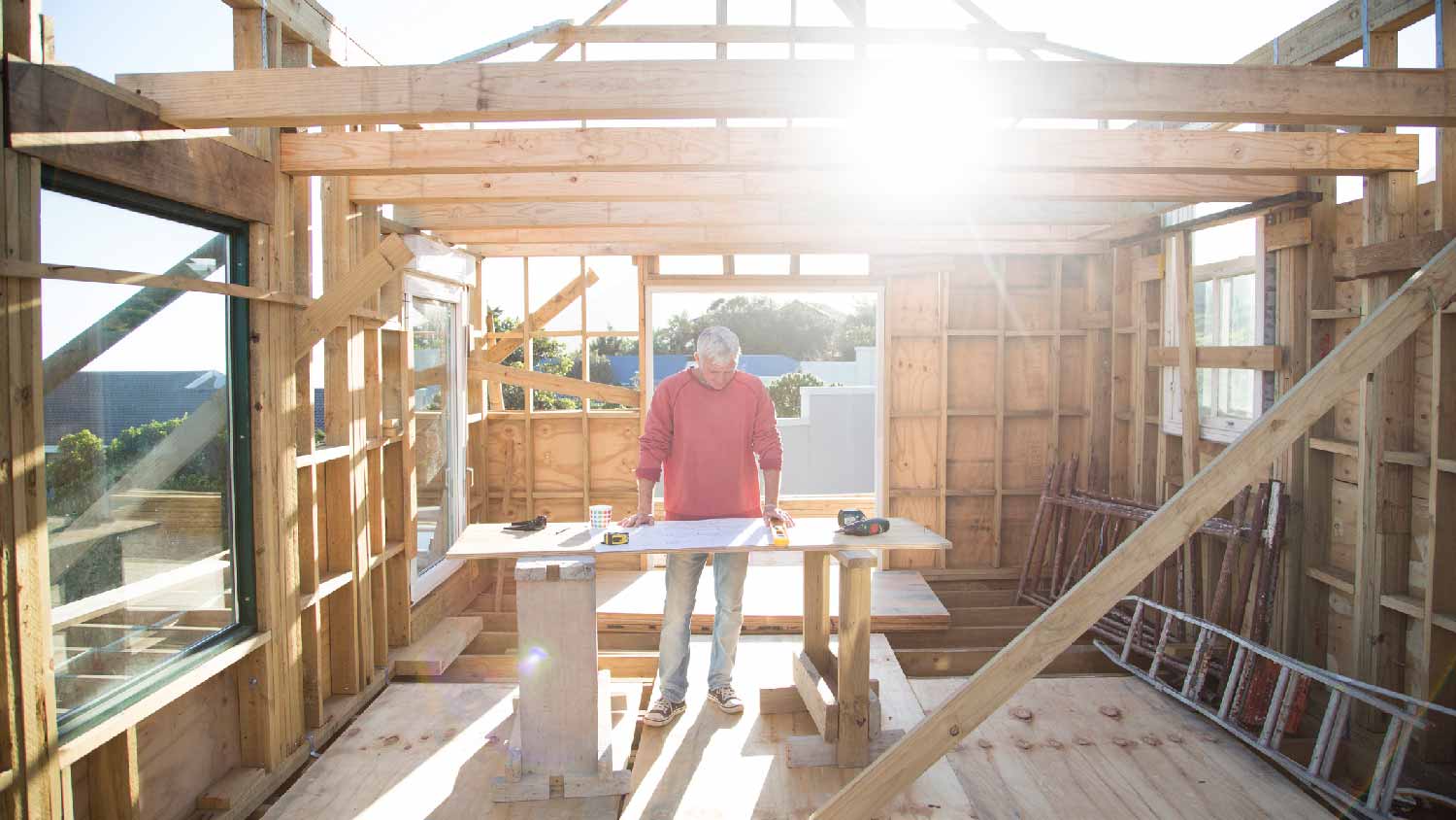 A home builder checking blueprints in a construction site