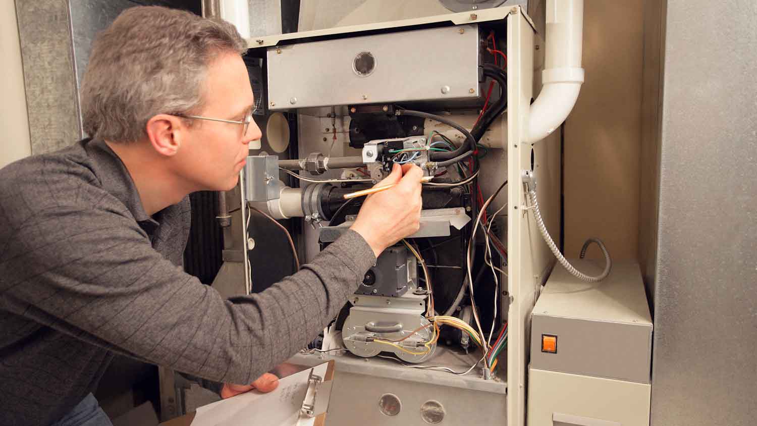 Technician inspecting furnace in the basement