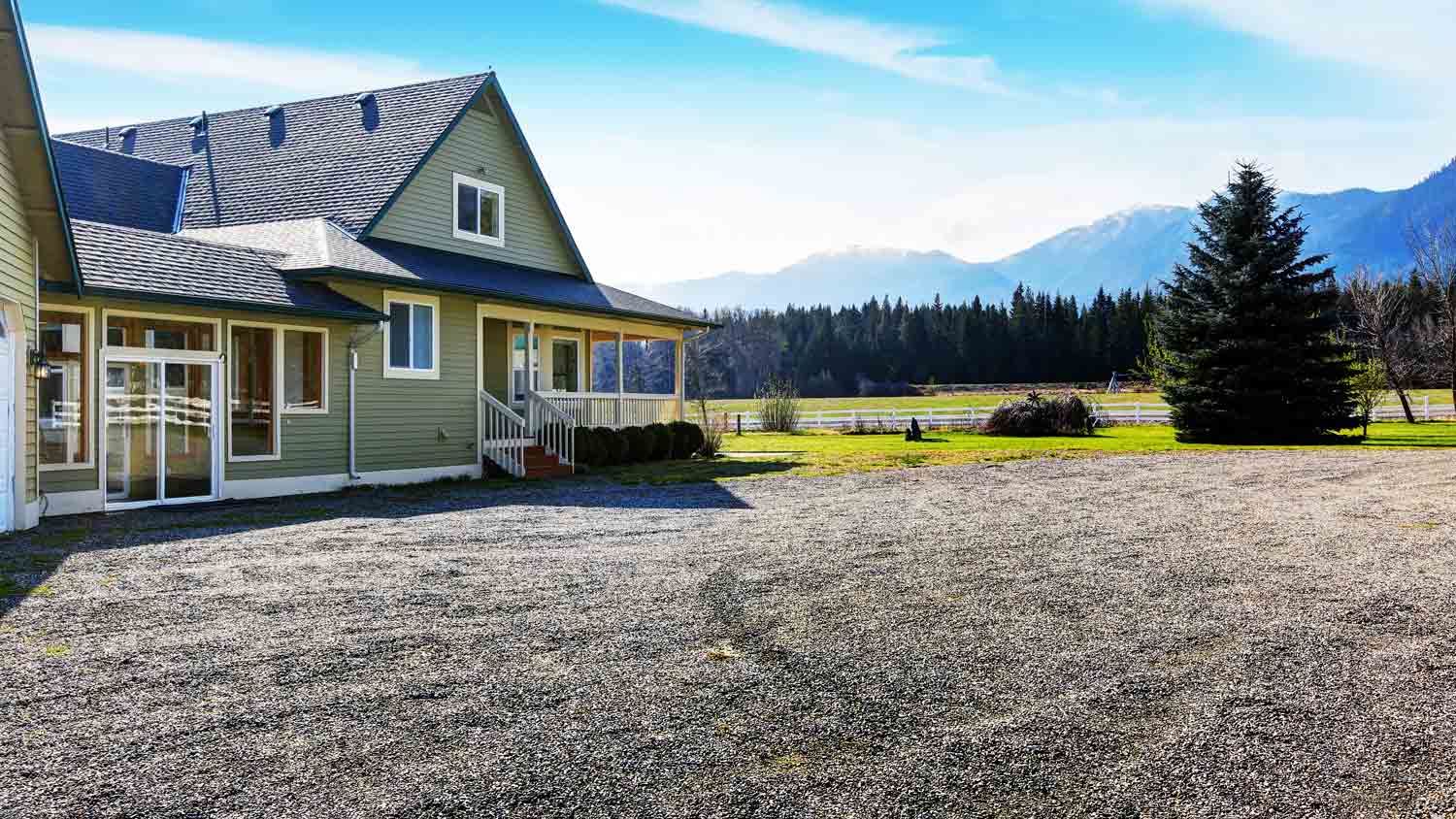 green home with gravel driveway