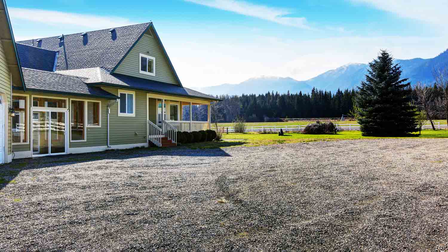 green home with gravel driveway 