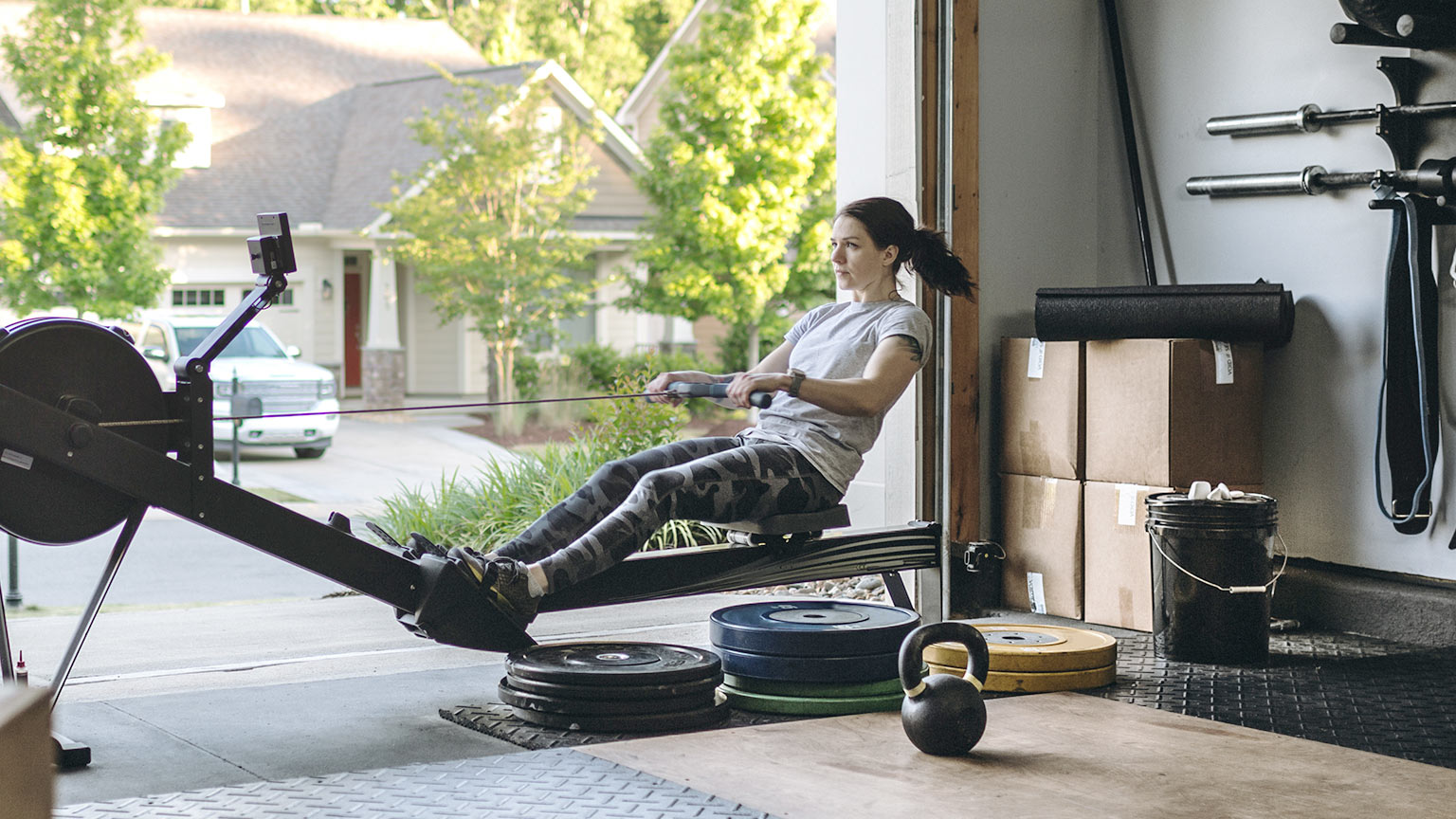 woman using rowing machine in home gym 