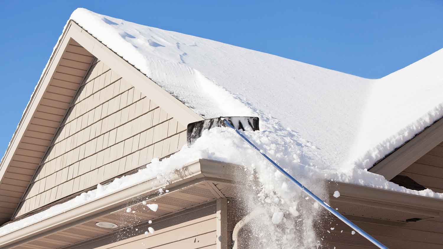 Removing snow from a roof with a roof rake