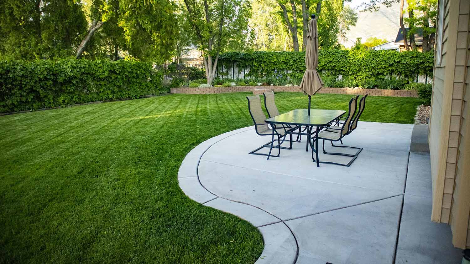 Concrete patio in shady backyard of home