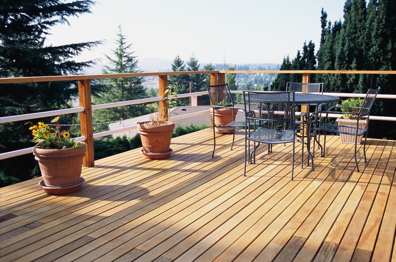 home wood deck with patio furniture overlooking hills with trees