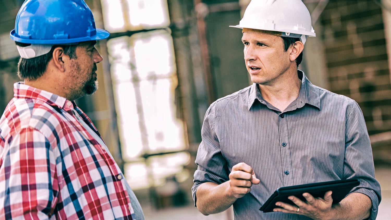 A homeowner holding a table discussing with a contractor