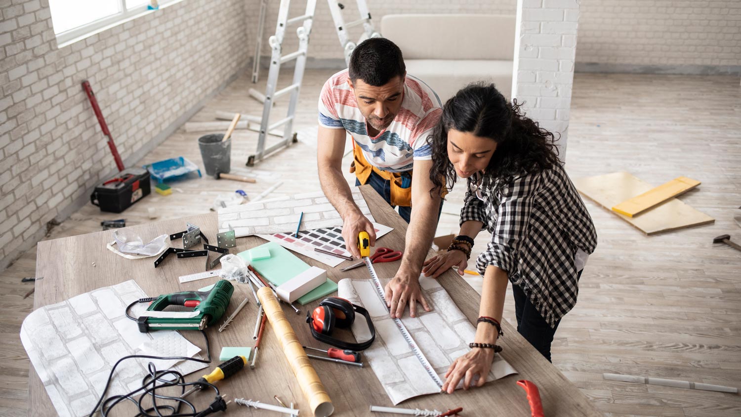 A homeowner looking at plans with a worker