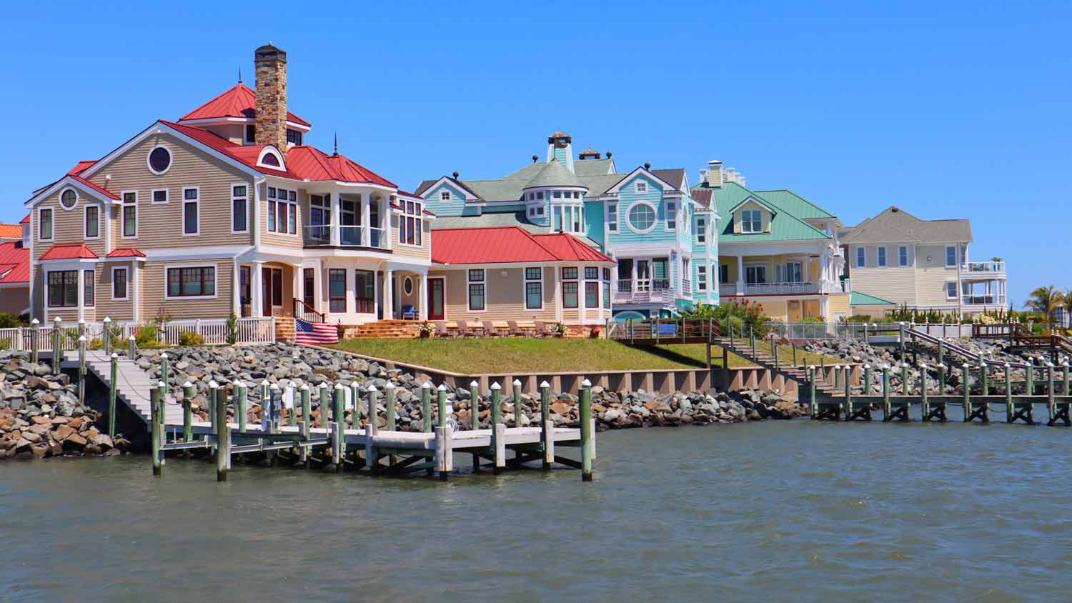 colorful row of homes with rip rap in front 