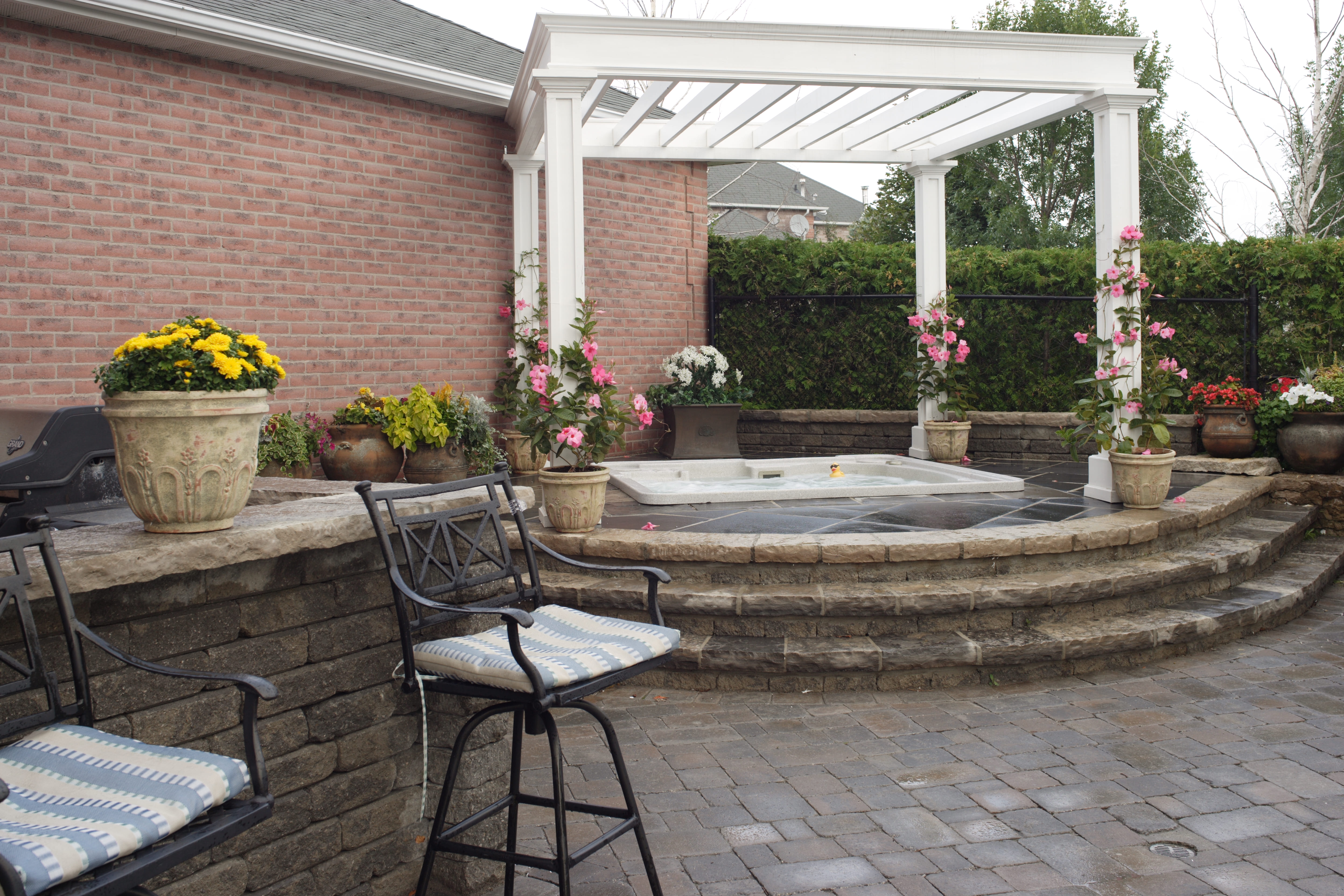 A hot tub built into a stone patio that curves around it 