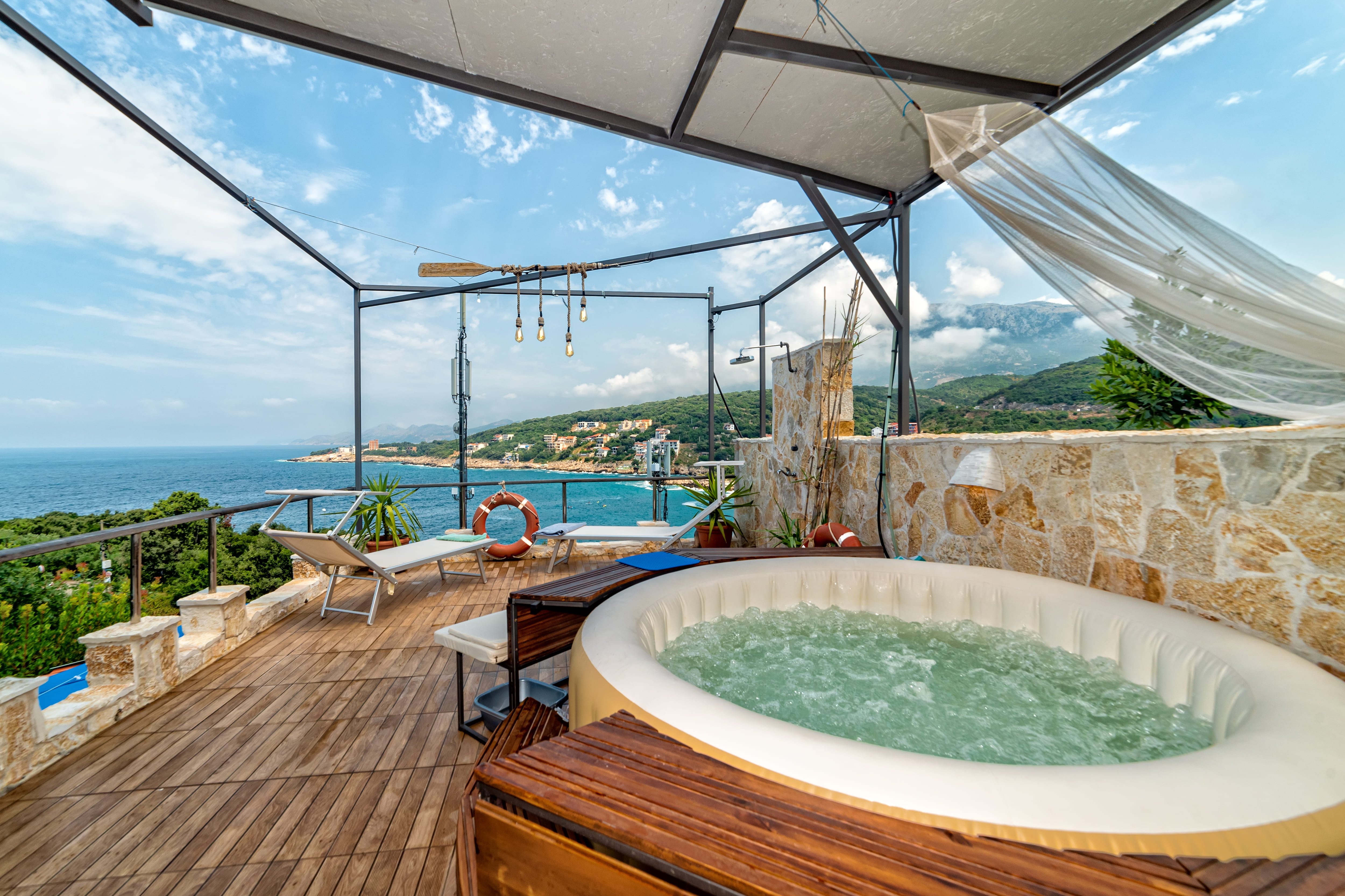 A deck overlooking an ocean with a small inflatable hot tub 