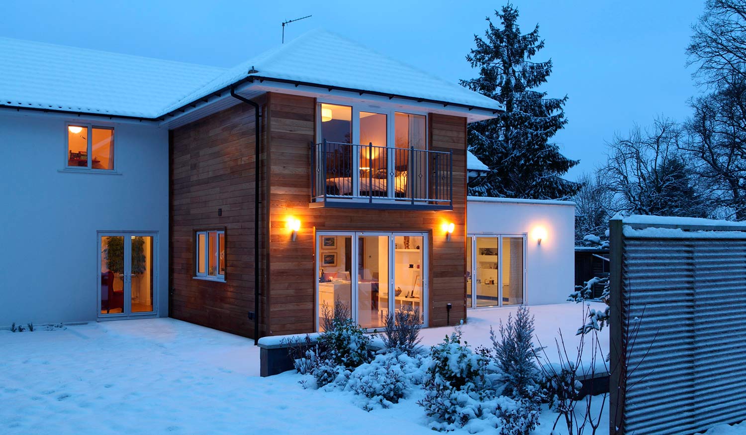 Exterior of house covered in snow at dusk