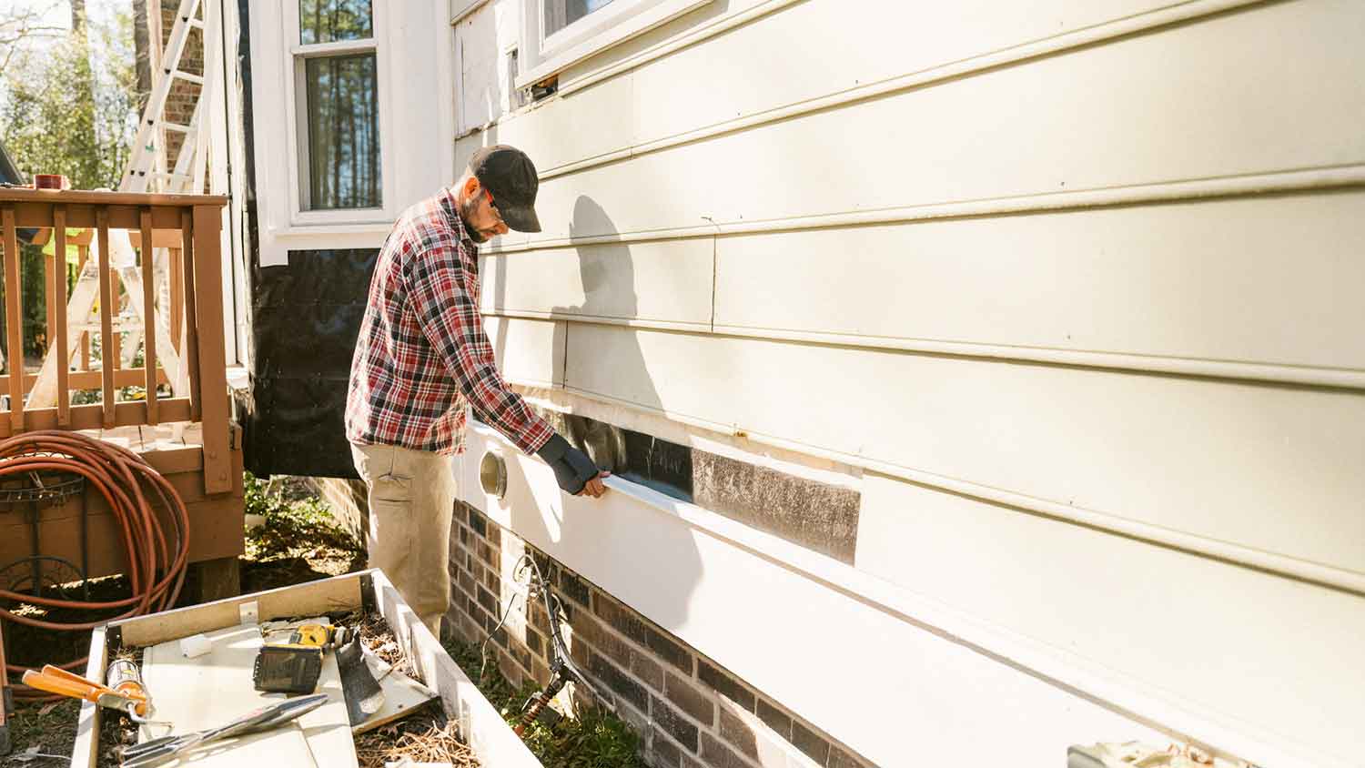 Contractor replacing a section of siding on the house