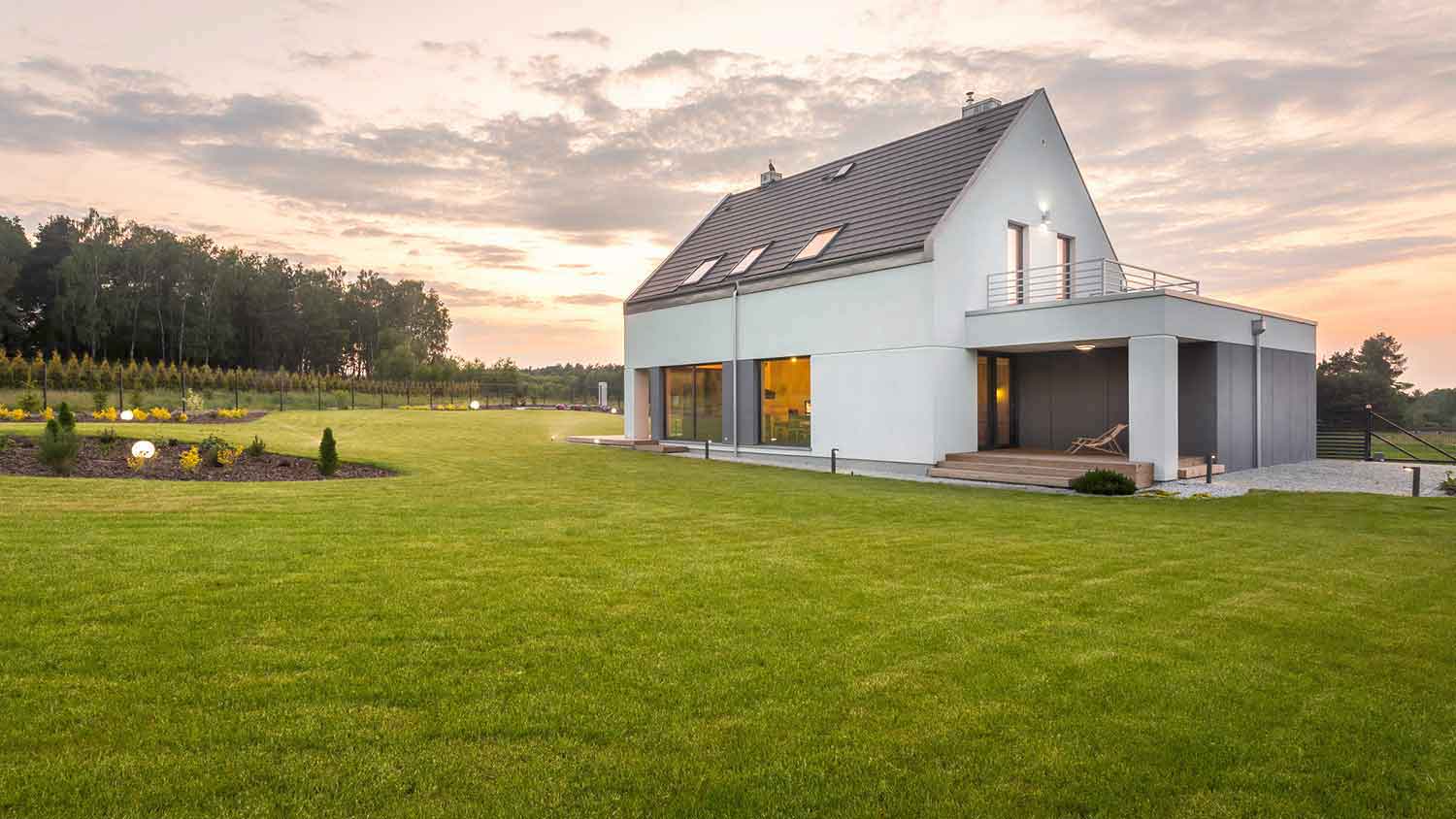 White modern house in the middle of a green field