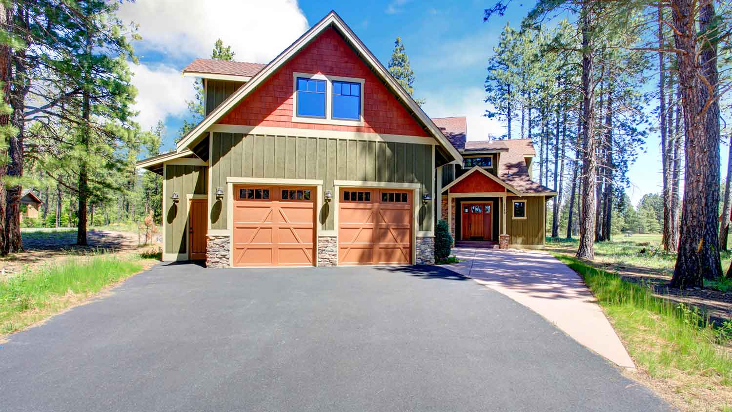 House surrounded by trees with an asphalt driveway