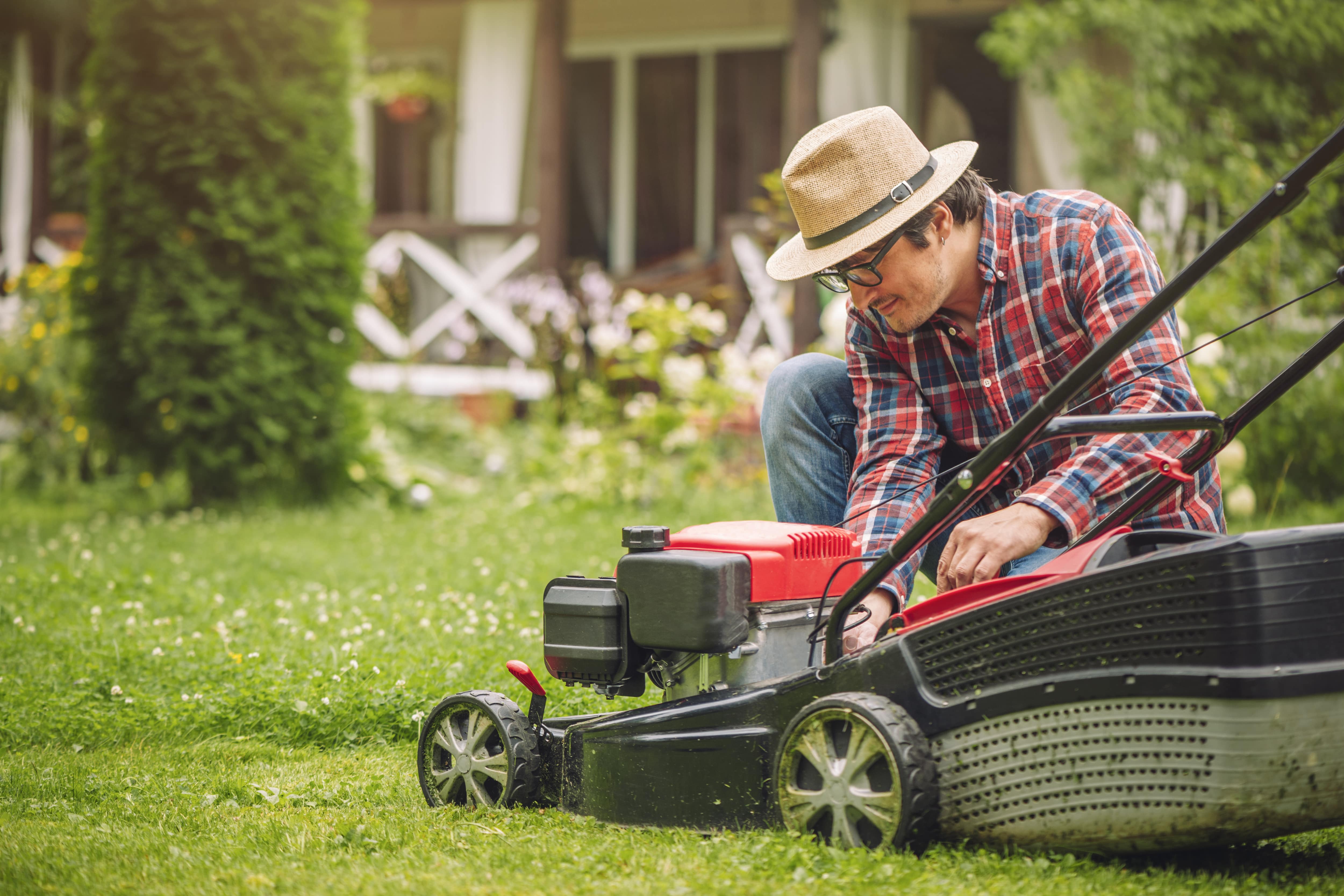 Man setting the height on the lawn mower