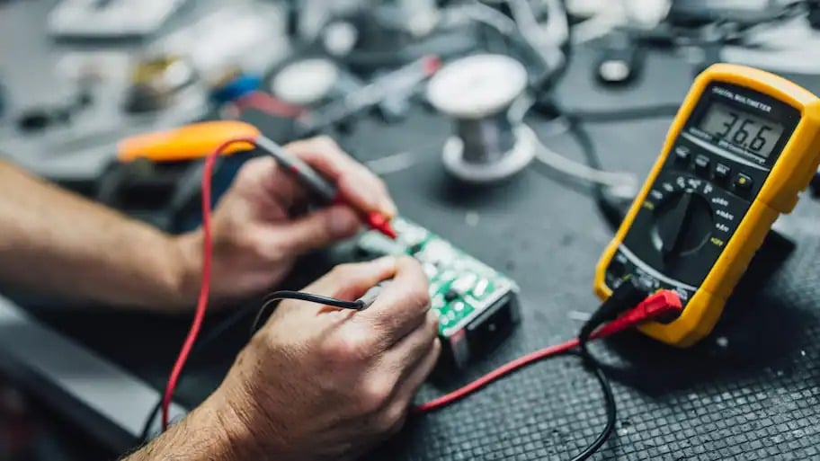 Man using a multimeter to measure resistance